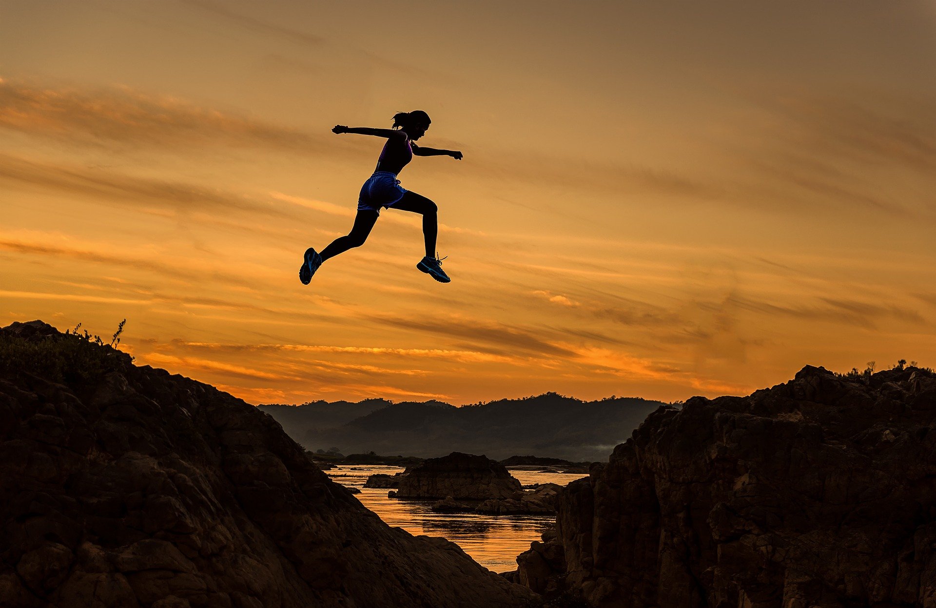 Woman jumping over puddles outside 