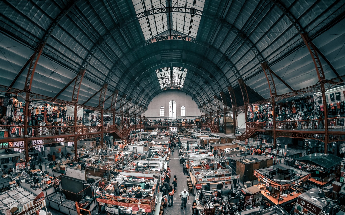 Panoramic view of warehouse market with multiple stalls set up