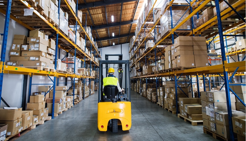 Man driving forklifk around warehouse