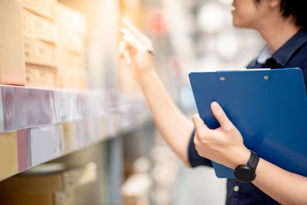 Person holding clipboard doing warehouse stocktake