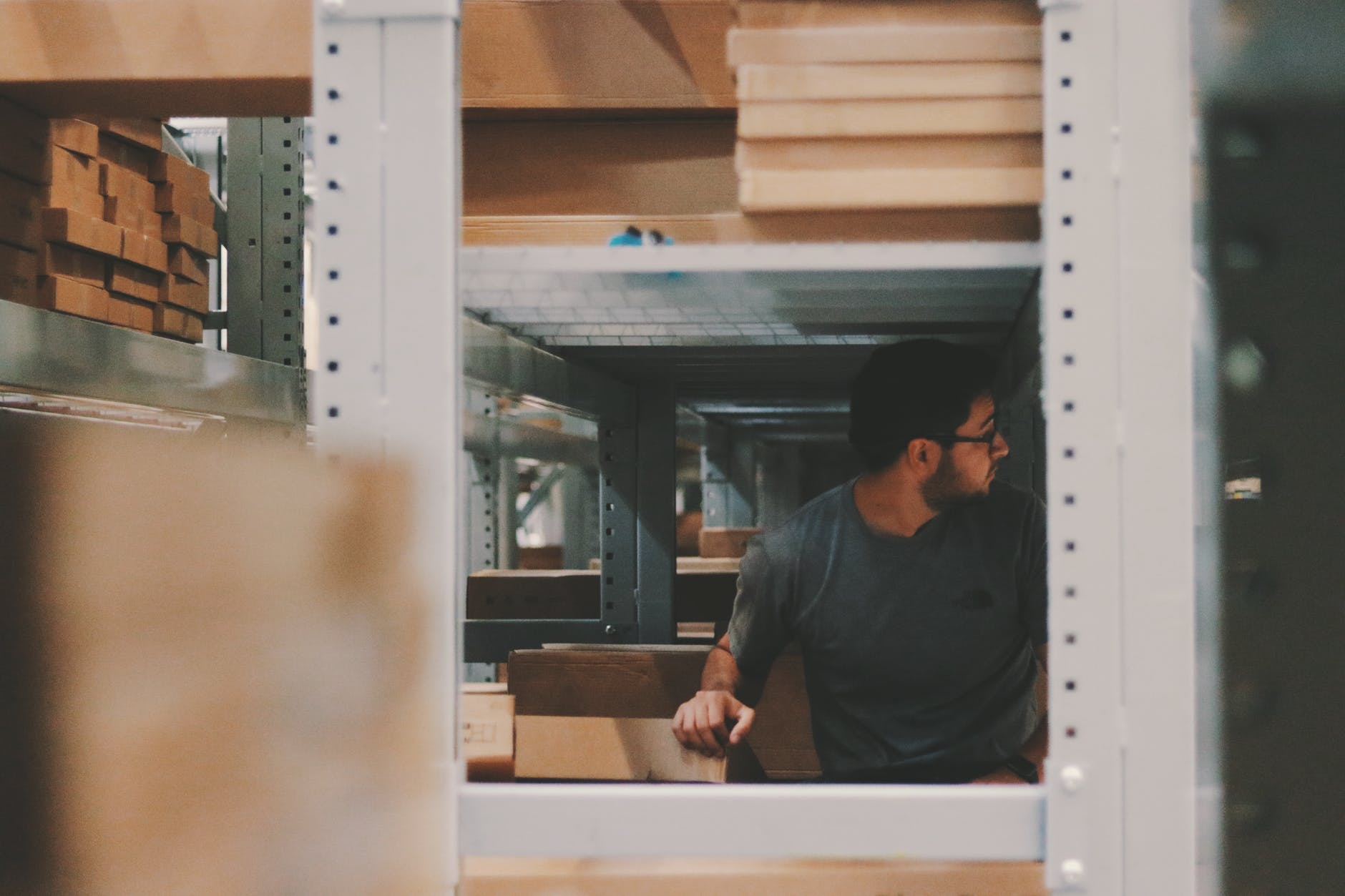 Man in warehouse shelves stocking with inventory