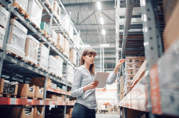 a woman doing an inventory check in a pallet warehouse