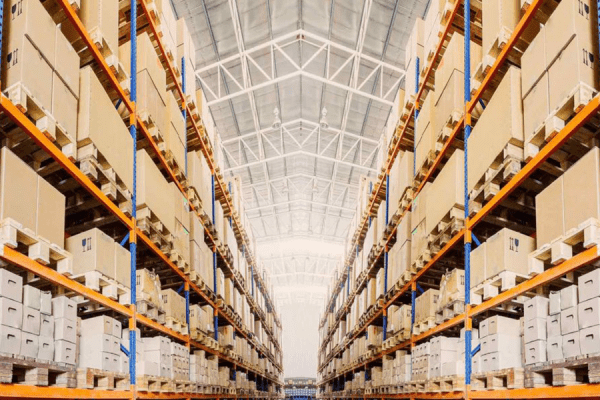 cardboard boxes stacked in pallet racks inside a warehouse