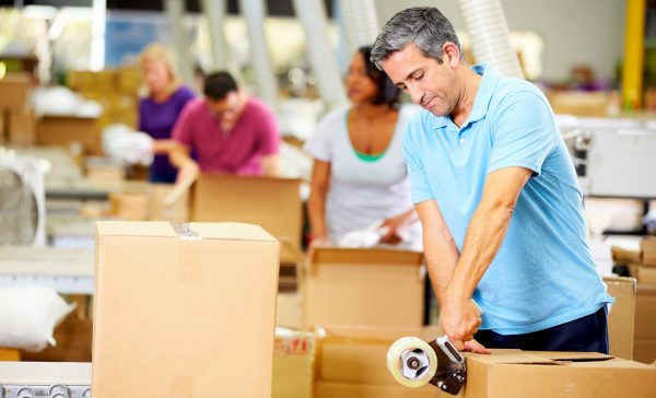 a group of people packing cardboard boxes