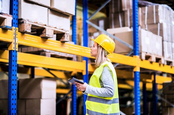 a woman working in a warehouse inspecting the inventory