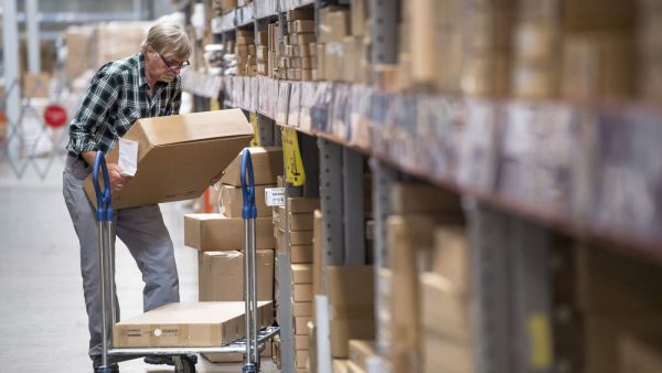 an old man stocking the pallet racks in a warehouse