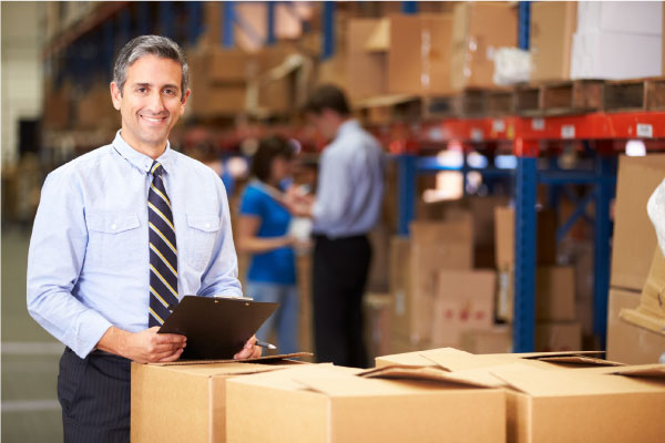 a happy businessman holding a chart in his warehouse