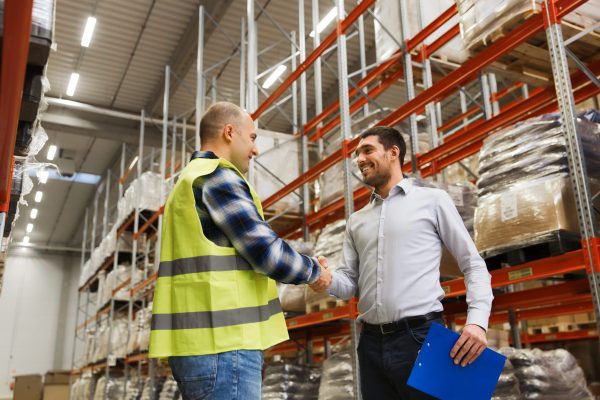 worker and businessmen with clipboard at warehouse