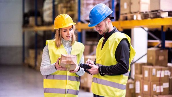 Two warehouse workers checking a package